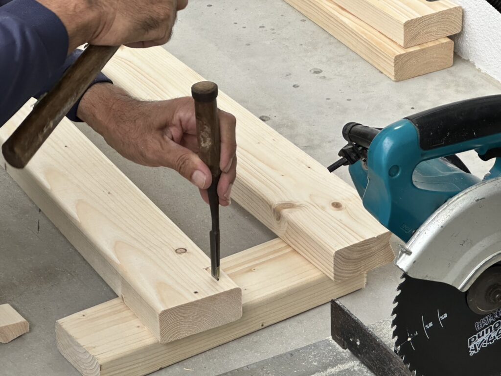 設置には、アジャスターと木材を活用し、天井と床に突っ張る形で柱を設け、そこにホワイトボードを吊り下げて設置しました。